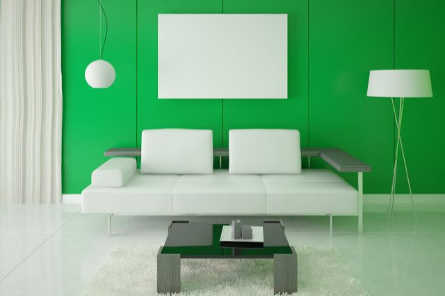 Modern likving room with white couch and green accent wall.