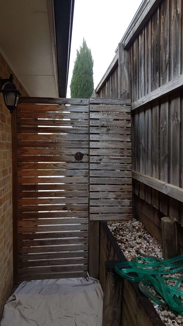 Salt-affected exterior timber fence near the coastline