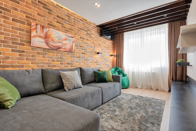 A living room interior design with a brick accent wall.