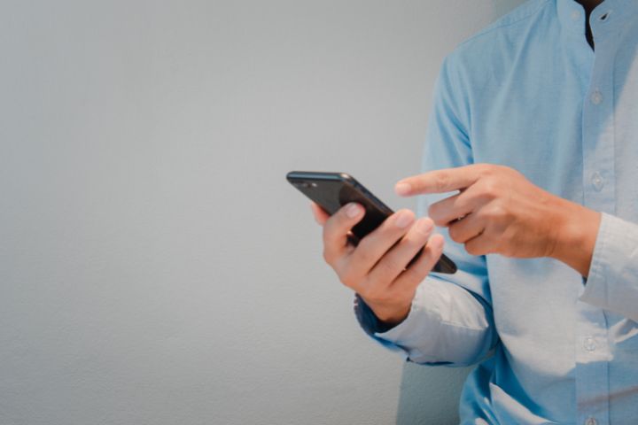 Close up photo of a hand holding a smartphone.