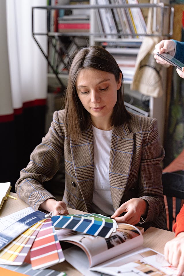 Woman Choosing a Color from a Sample Palette.