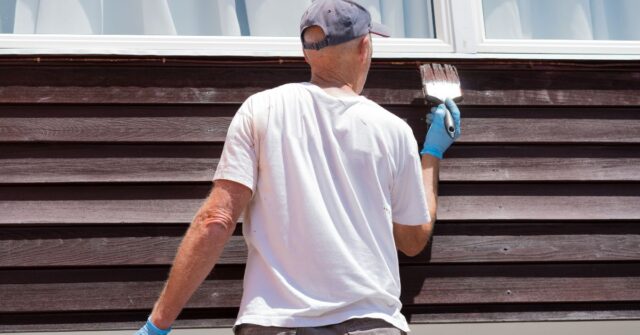 A man painting the exterior of a house.