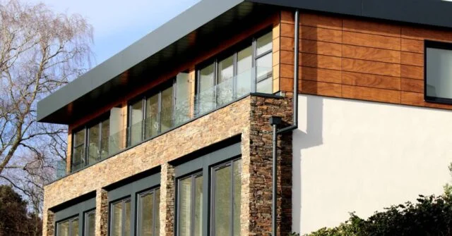 Two story home with a mix of small bricks, timber and painted walls.