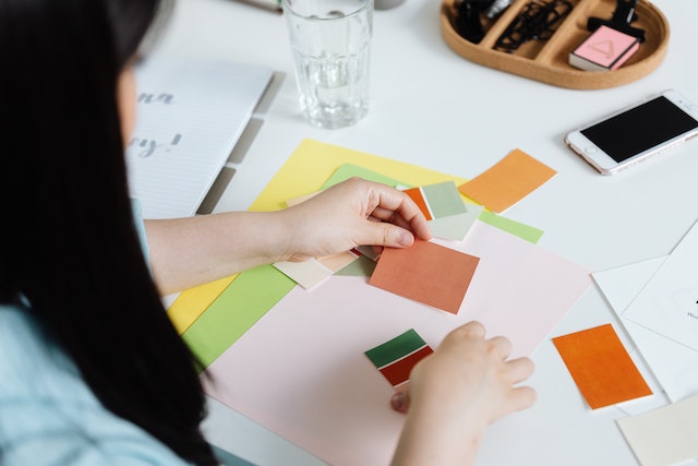 A woman interior designer holder various color swatches palette.