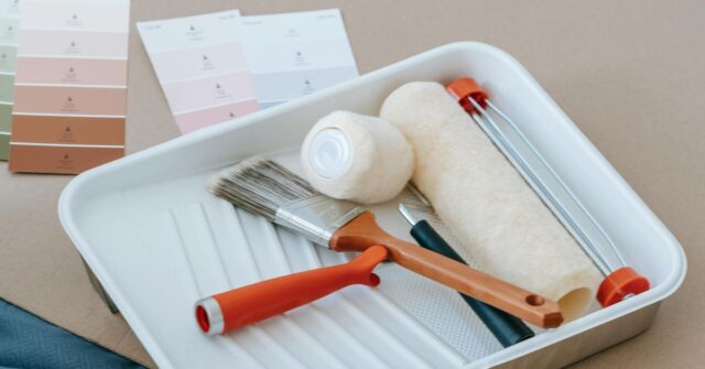 Paint Roller And Brush On Plastic Tray.