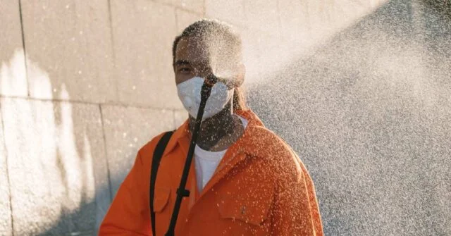 A man pressure a washing an exterior wall.