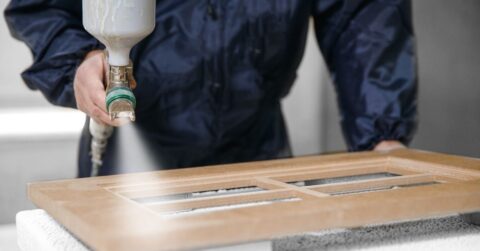 Application white color on facade kitchen furniture, spraying device.