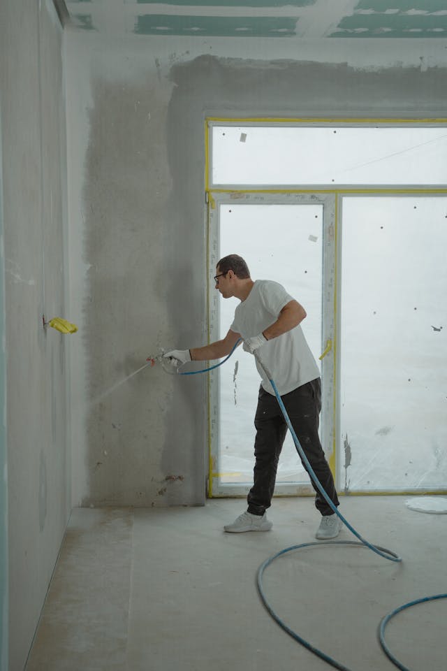 Man in White Dress Shirt and Black Pants Holding a Spray Hose.
