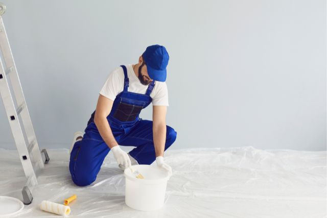 A professional painter mixing the paint before starting its job.