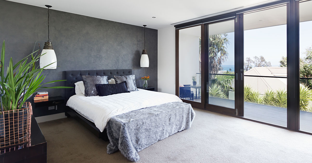 Grey feature wall in bedroom that has white walls and ceiling.