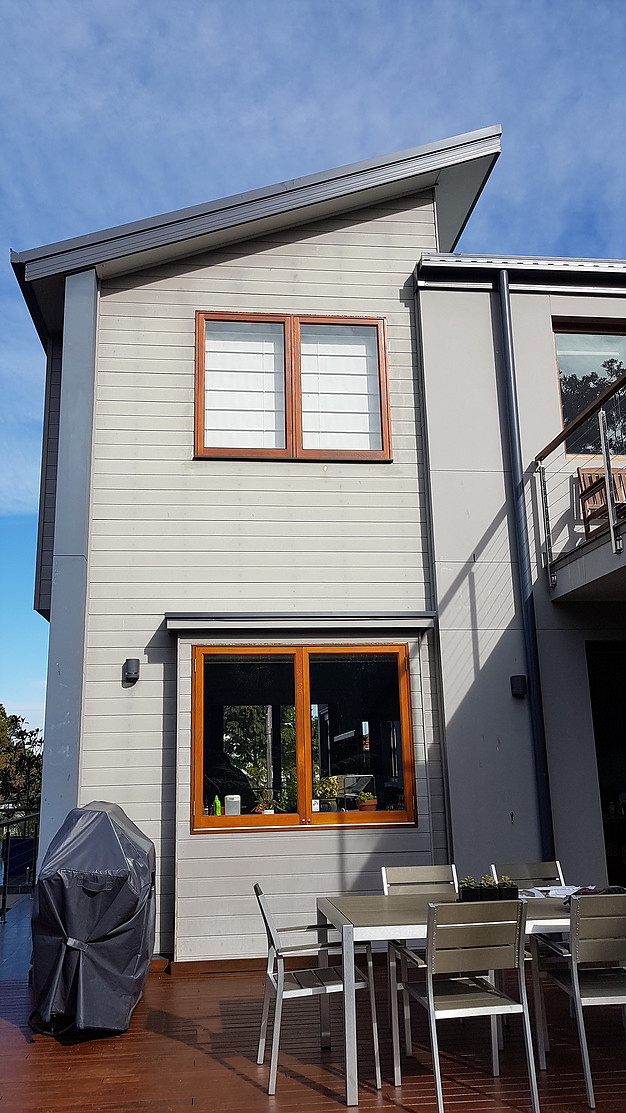 Outside view of 2 storey home that has been freshly painted in grey with dark blue trim.