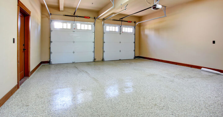 Large empty double door garage with a light shiny coating on the floor.
