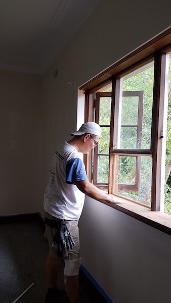 Sanding the timber windows before priming and applying first coat.