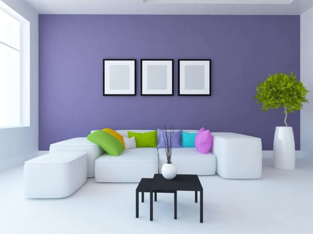 A home with a purple feature wall that goes well with their white couch.