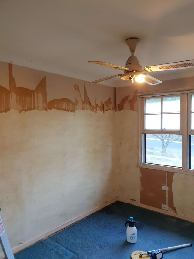 Professional painter preparing apartment walls before painting