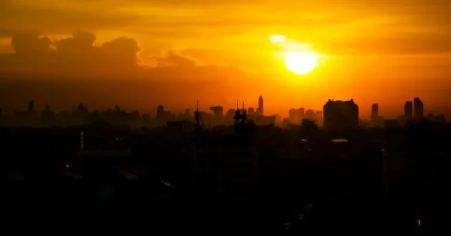 Sunset with an orange skyline indicating its been a hot day over a city skyline.