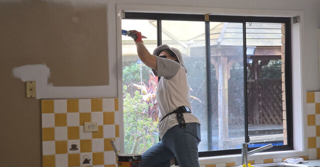 Experiened painter painting interior window trims in a kitchen